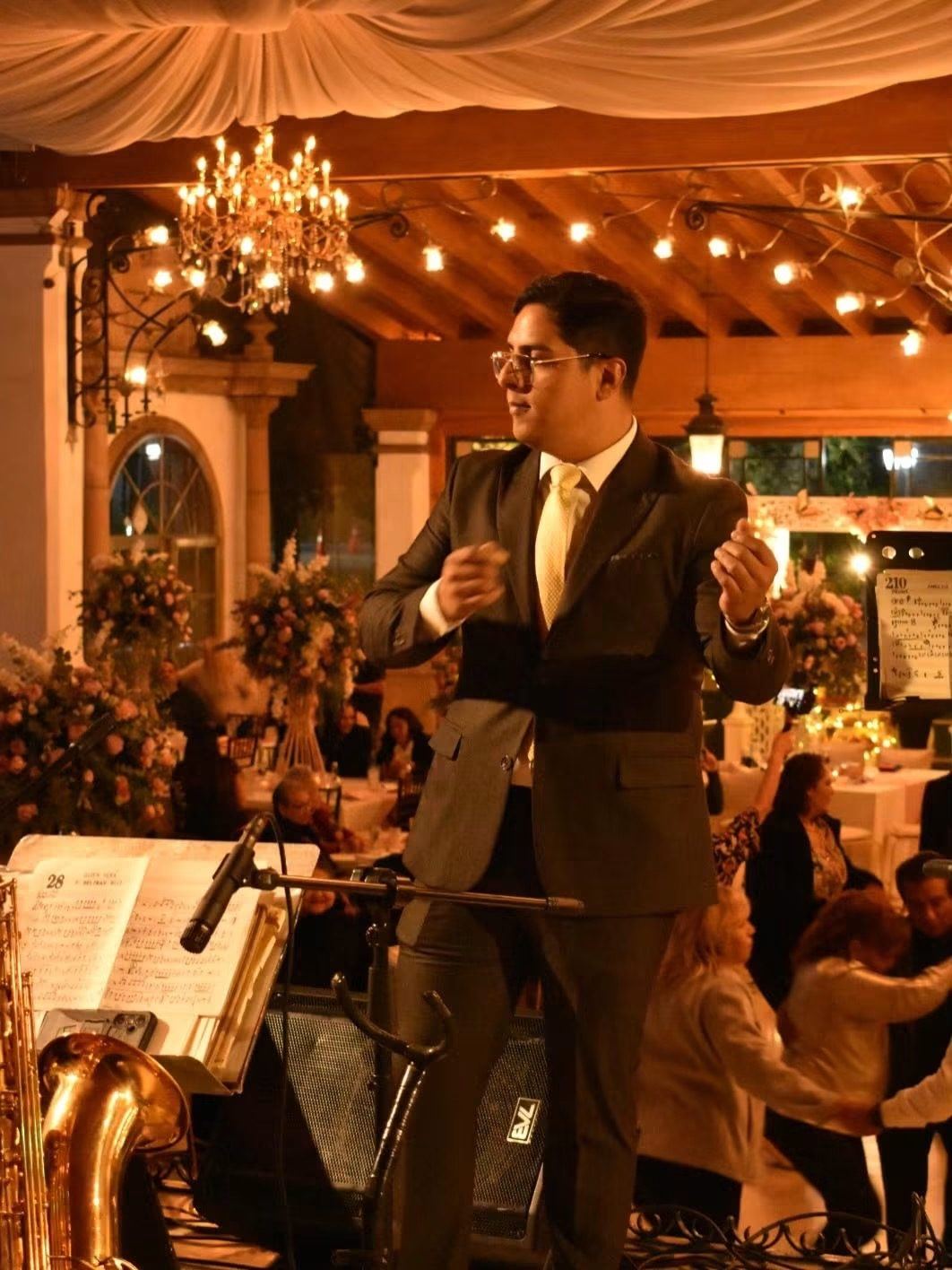 Marco Reyes dirigiendo bajo los candiles de un salón